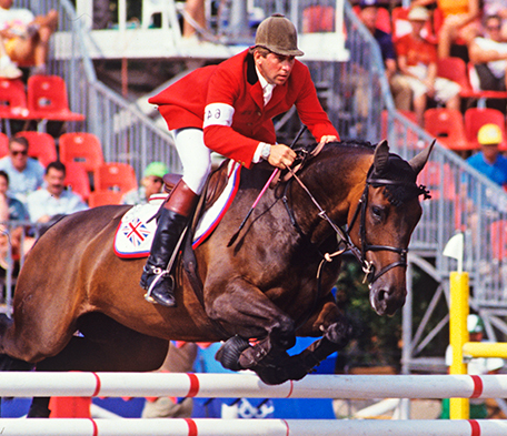 Show jumping rider clearing a fence
